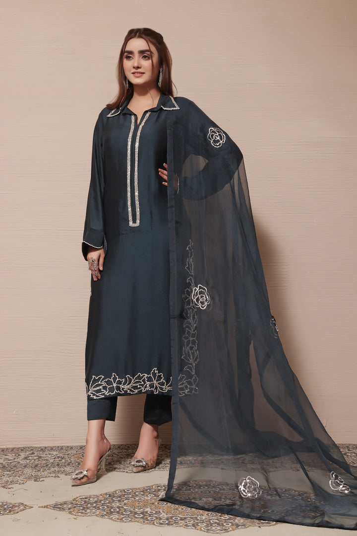  Embrace festive elegance with this teal sheesha silk outfit, featuring an organza dupatta and exquisite embellishments and embroidery details.