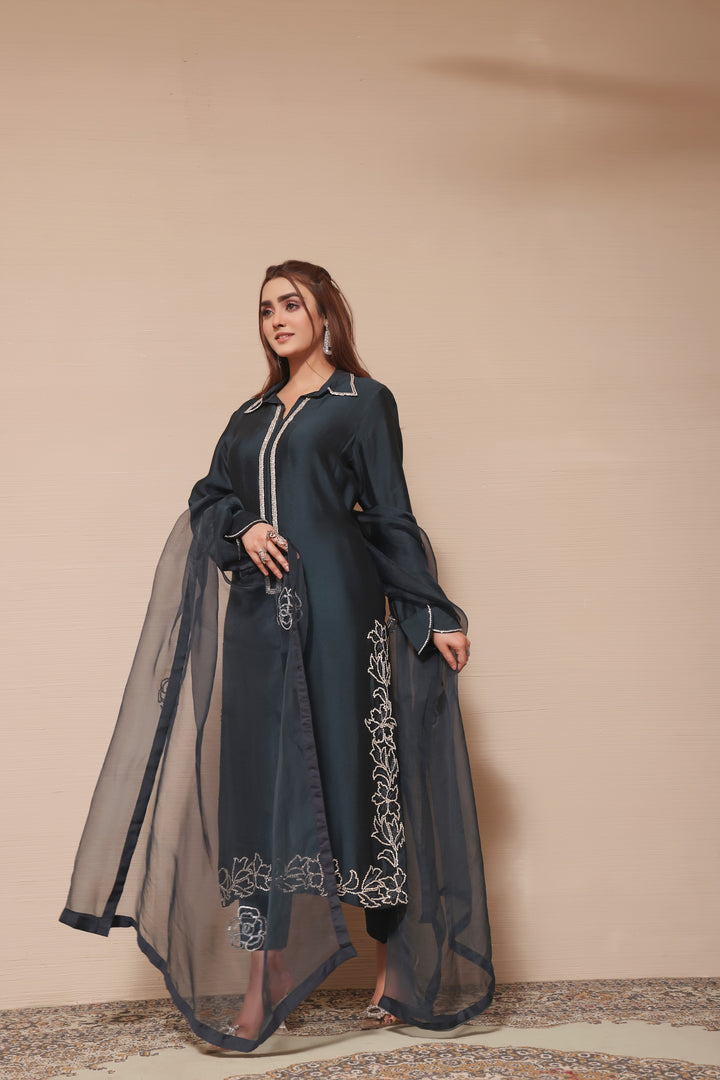  Embrace festive elegance with this teal sheesha silk outfit, featuring an organza dupatta and exquisite embellishments and embroidery details.