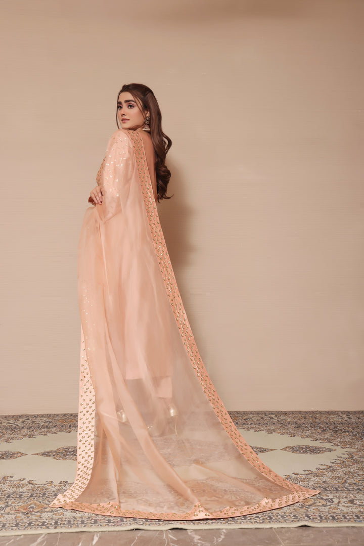  Adorn yourself in peach sheesha silk with exquisite hand-embellished zardozi and sequence work, paired perfectly with elegant straight pants.