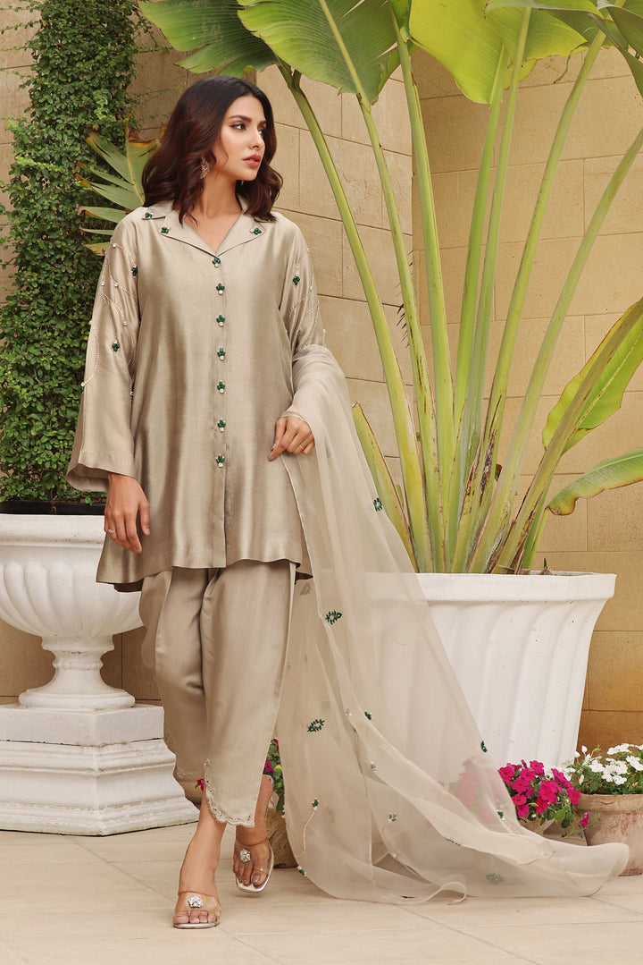  Behold the regal charm of 'Mehrab' — a front open style adorned with emerald and Swarovski work, paired with a cutwork shalwar and organza dupatta.