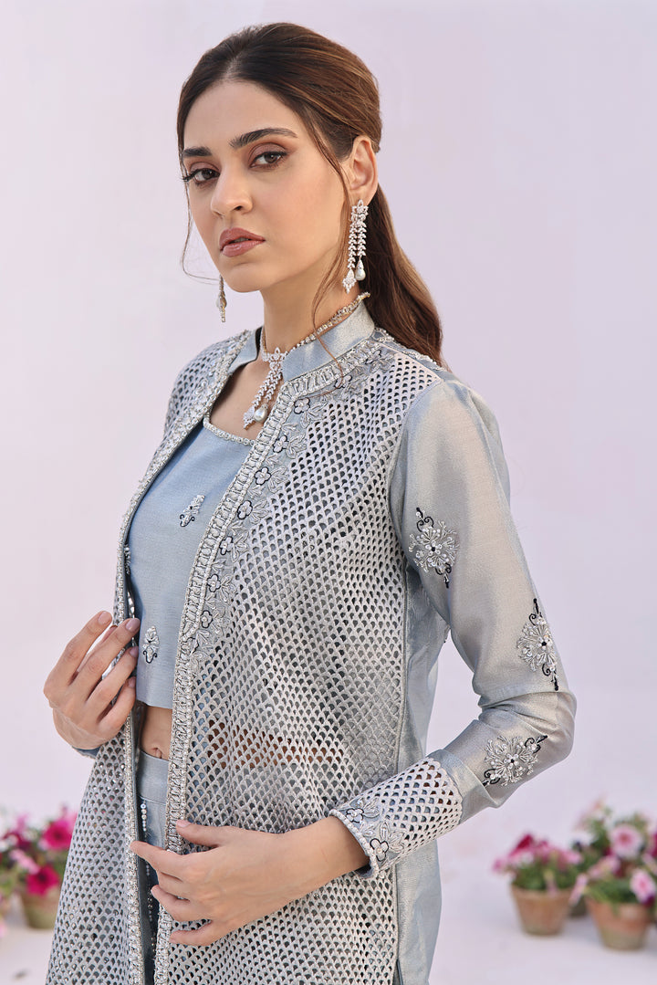  Step into elegance with Fiza by Mona Imran, crafted from luxurious lambha tissue with mesmerizing cutout pattern jaal adorned with pearls and diamonte work.