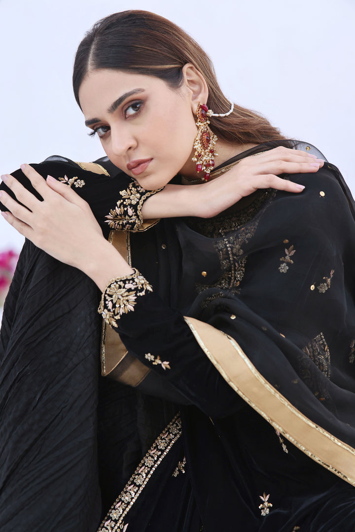 Immerse yourself in the timeless allure of '𝐊𝐨𝐡-𝐞-𝐊𝐚𝐥𝐚𝐚𝐧' — where black velvet meets the artistry of hand zardozi work, adorning the daman, neck, and sleeves.