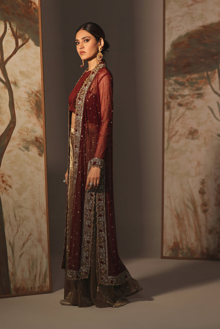  Step into timeless elegance with Gulabposh by Mona Imran, featuring a deep maroon kora net jacket adorned with exquisite antique gold appliquéd borders.