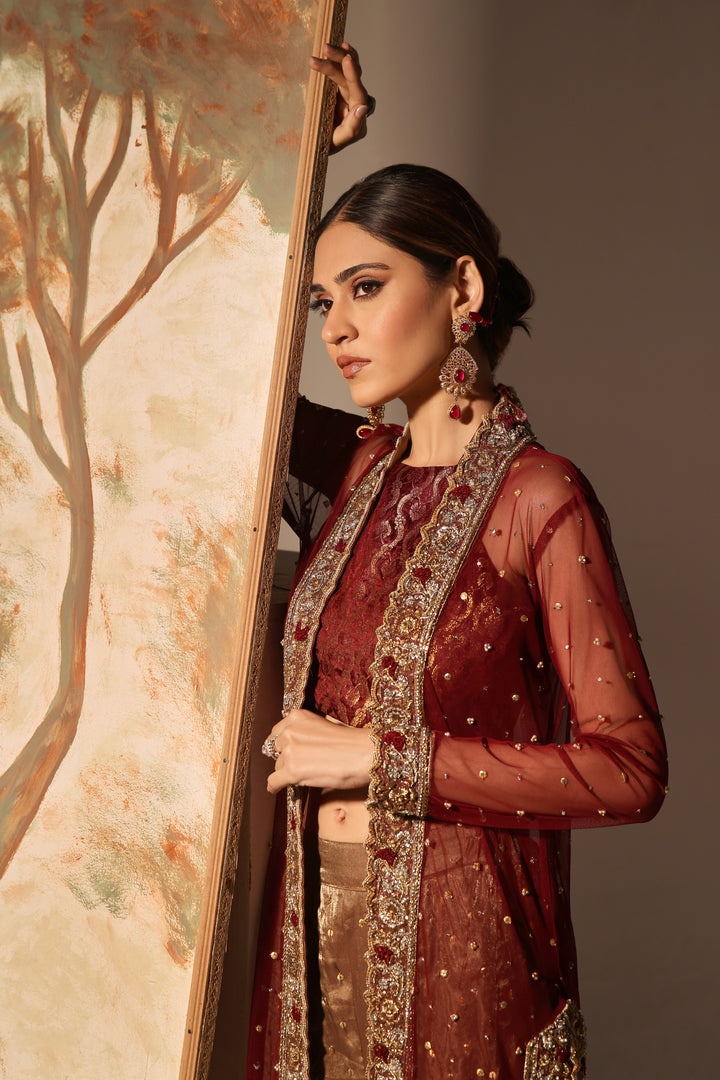  Step into timeless elegance with Gulabposh by Mona Imran, featuring a deep maroon kora net jacket adorned with exquisite antique gold appliquéd borders.