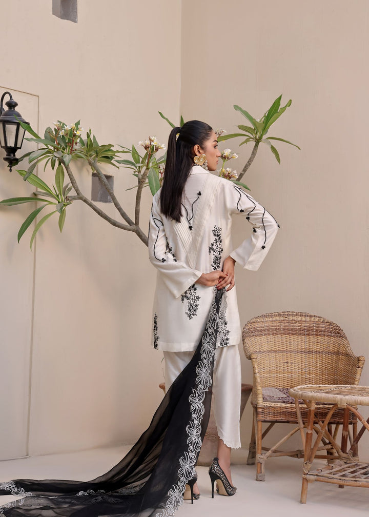  Step into elegance with Mona Imran's Noor, featuring a trendy front open shirt with black stones and intricate embroidery for a modern look.	